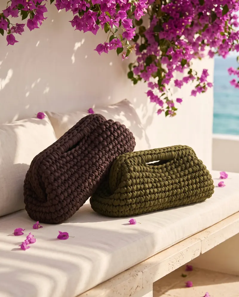 Due clutch a rotolo, verde oliva e marrone, su una panca sotto la bouganville